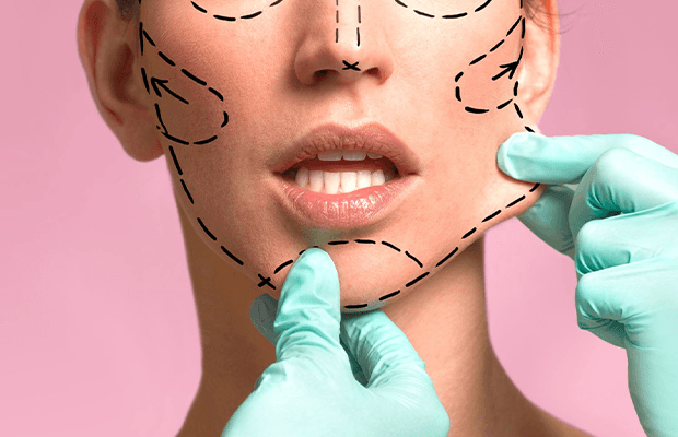 Cosmetic surgeon marking facelift treatment lines on woman’s face before plastic surgery procedure